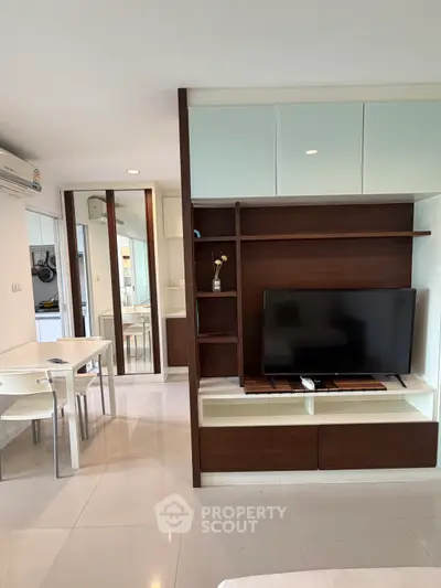 Modern living room with sleek TV unit and dining area in open layout apartment