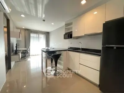 Modern kitchen with sleek design and breakfast bar in open-plan apartment