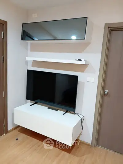 Modern living room with sleek TV setup and wooden flooring