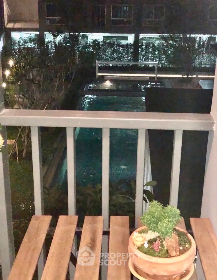 Charming balcony view overlooking a serene pool, perfect for relaxation and leisure.