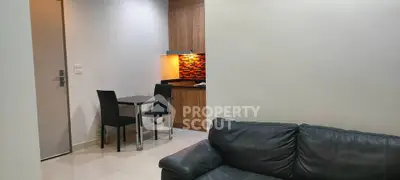 Modern apartment interior with cozy living room and compact kitchen area featuring stylish furniture.