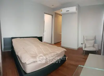 Modern bedroom with wooden flooring and air conditioning unit