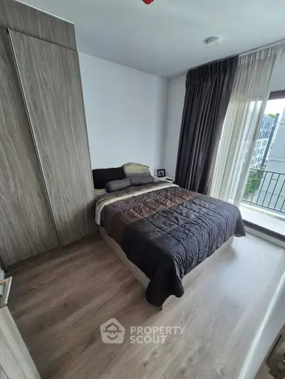 Modern bedroom with large window and stylish wooden flooring