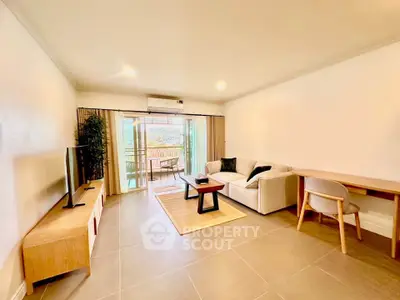 Spacious living room with modern furniture and balcony view in a stylish apartment.