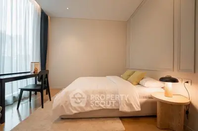 Modern bedroom with cozy lighting and elegant decor, featuring a comfortable bed and stylish desk.