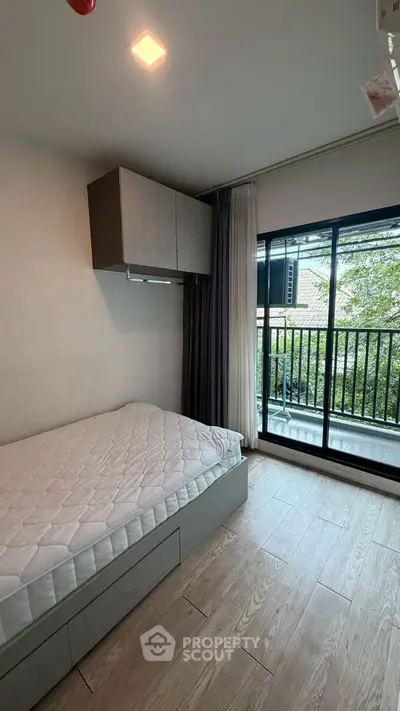 Cozy bedroom with balcony access and natural light