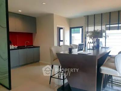 Modern kitchen with sleek bar seating and vibrant red backsplash