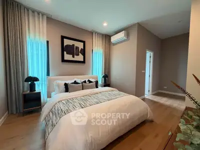 Modern bedroom with stylish decor and natural light, featuring a cozy bed and elegant furnishings.
