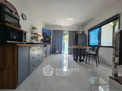 Spacious kitchen with modern appliances and open layout, featuring sleek cabinetry and ample natural light.