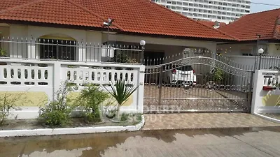 Charming suburban home with red-tiled roof and secure gated entrance, perfect for family living.