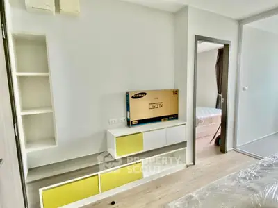 Modern apartment interior with stylish built-in storage and new LED TV, showcasing a bright and inviting living space.