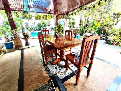 Charming outdoor dining area with wooden furniture and lush garden view
