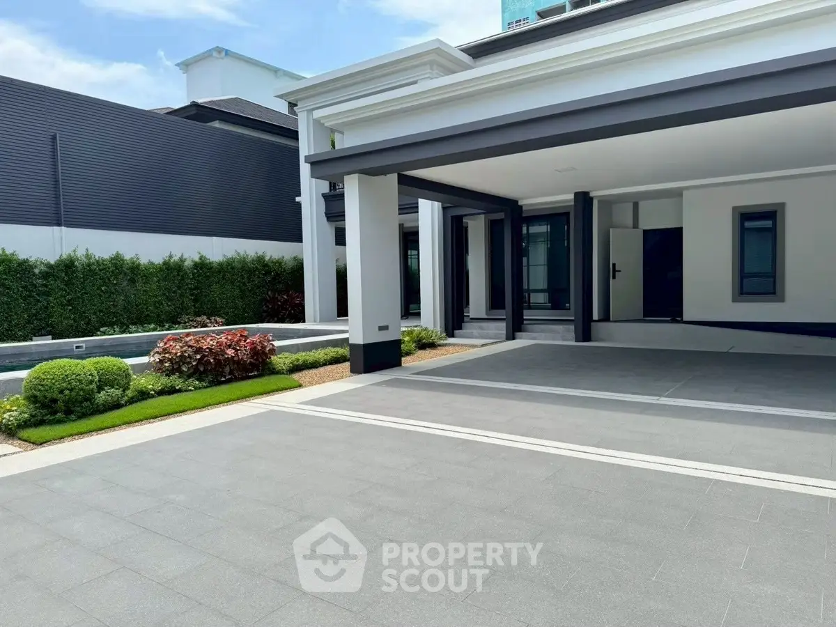 Luxurious modern home exterior with spacious driveway and manicured garden, perfect for upscale living.