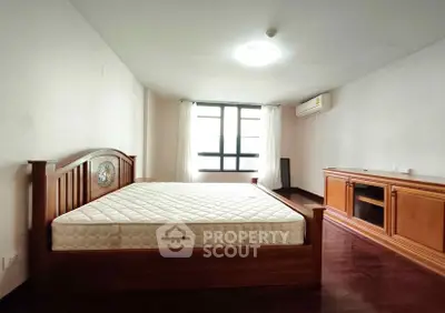 Spacious bedroom with wooden furniture and natural light