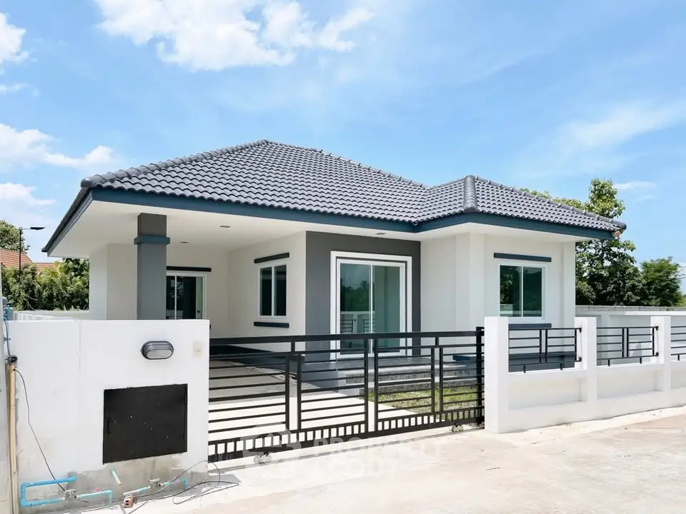 Modern single-story house with sleek design and spacious driveway under a clear blue sky.