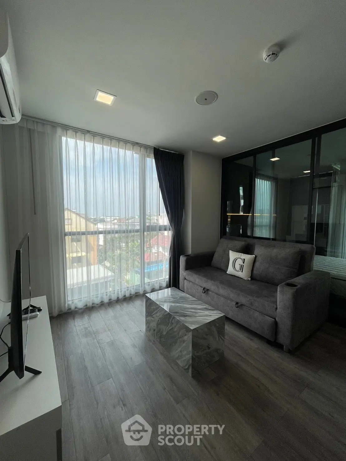 Modern living room with sleek design and large window offering natural light.