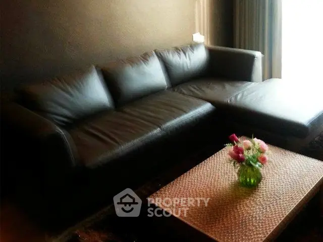 Stylish modern living room with sleek black leather sofa and elegant coffee table.