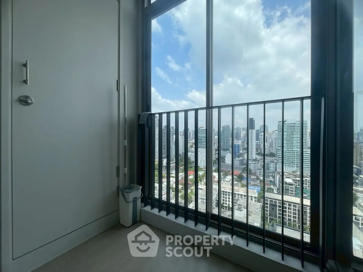 Stunning high-rise city view from modern apartment balcony with sleek railing.
