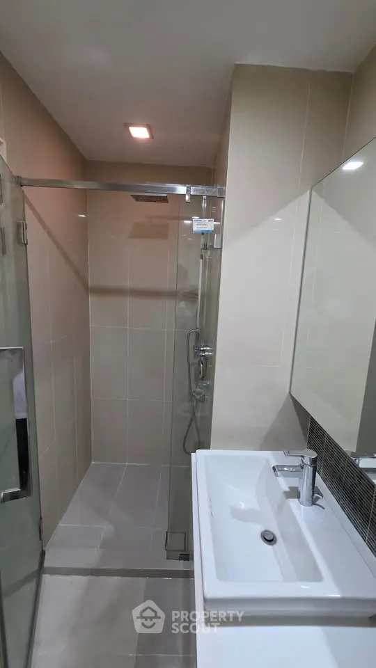 Modern bathroom with sleek shower and elegant sink in a contemporary apartment.