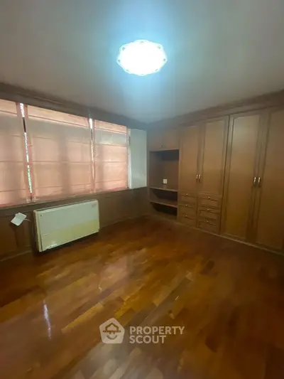 Spacious bedroom with wooden flooring and built-in wardrobe