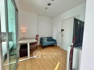 Modern study room with sleek furniture and wooden flooring in a bright apartment.