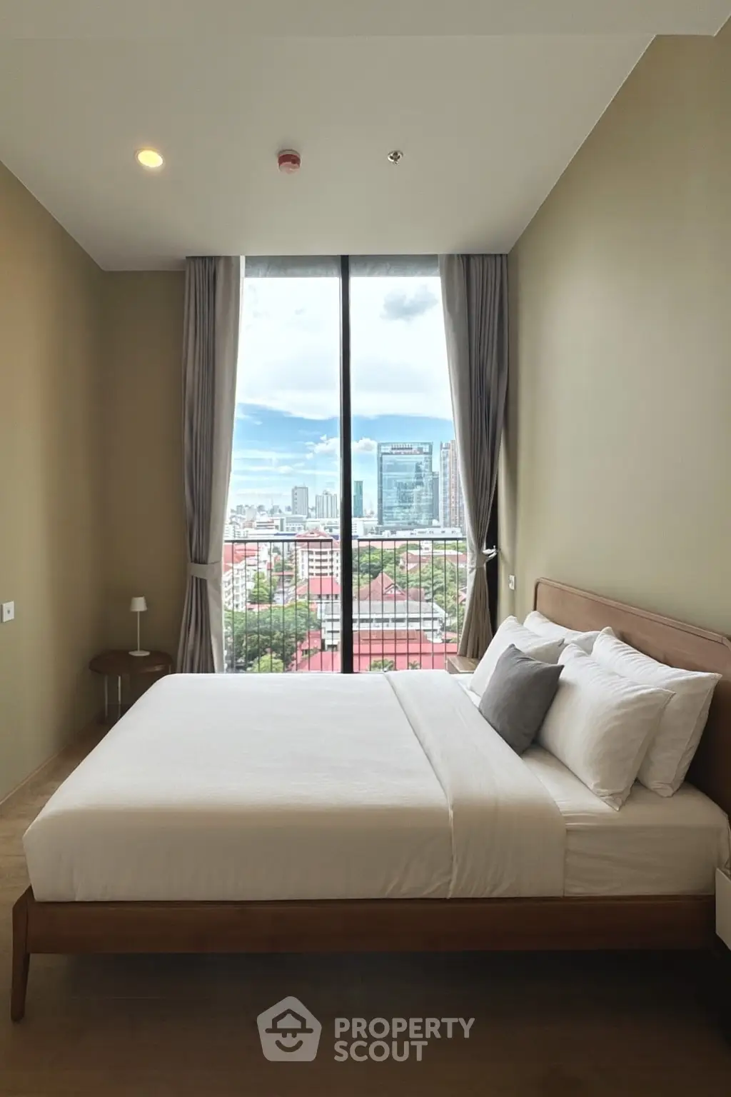 Modern bedroom with large window offering stunning city view