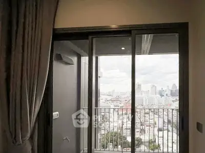 Modern apartment balcony with stunning city view through glass doors.
