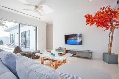 Modern living room with stylish decor and large sliding glass doors opening to a patio.