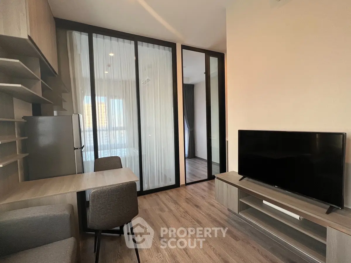 Modern living room with sleek furniture and glass partition in a stylish apartment