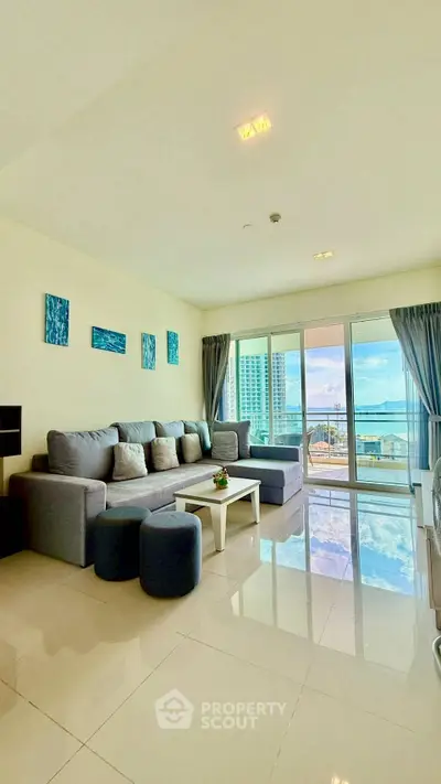 Spacious living room with modern decor and stunning ocean view from large windows.