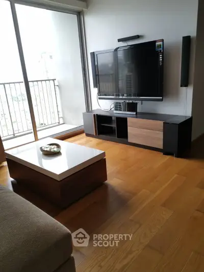 Modern living room with sleek TV stand and large window balcony view.
