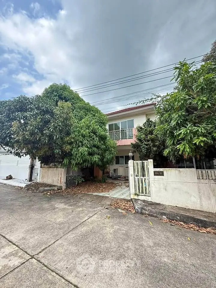Charming two-story house with lush greenery and spacious driveway in a serene neighborhood.
