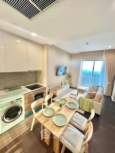Modern living room with open kitchen, stylish decor, and large window offering a stunning view.