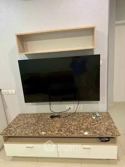 Modern living room with wall-mounted TV and sleek storage unit