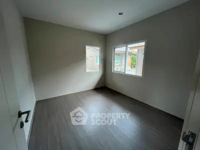 Spacious empty room with large windows and modern flooring, ideal for customization.