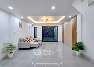 Spacious modern living room with elegant lighting and sleek tile flooring, perfect for stylish living.