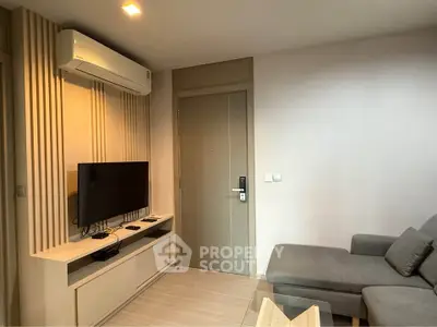 Modern living room with sleek design, featuring a wall-mounted TV and comfortable gray sofa.