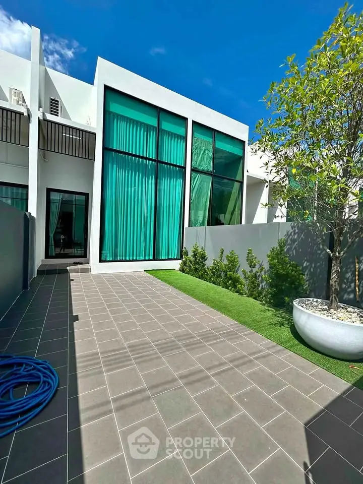 Modern townhouse exterior with large windows and landscaped garden