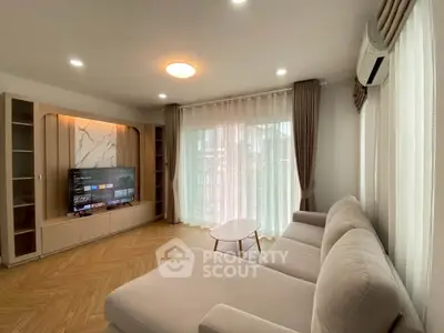 Spacious living room with modern decor, large sofa, and entertainment center, perfect for relaxation.