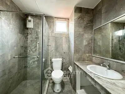Luxurious marble bathroom with glass shower and large mirror