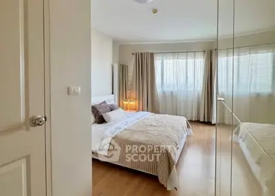 Spacious bedroom with large windows and mirrored closet doors, offering ample natural light and modern decor.