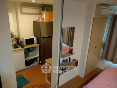 Compact apartment interior with kitchen and bedroom, featuring modern appliances and efficient use of space.