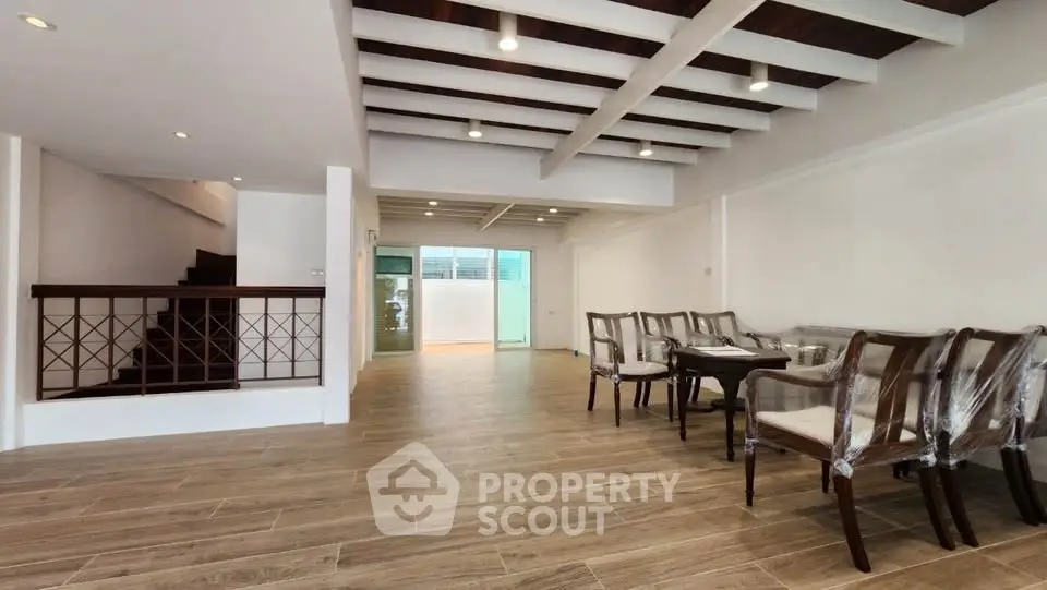 Spacious open-plan living room with elegant dining area and modern wooden flooring.