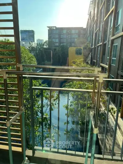 Modern apartment balcony with pool view and lush greenery