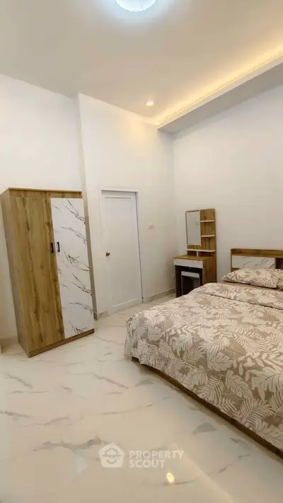 Elegant bedroom with modern decor and marble flooring, featuring a stylish wardrobe and cozy bed.