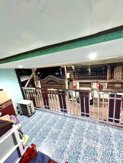 Charming balcony with stylish railing and tiled floor overlooking a secure gated entrance.