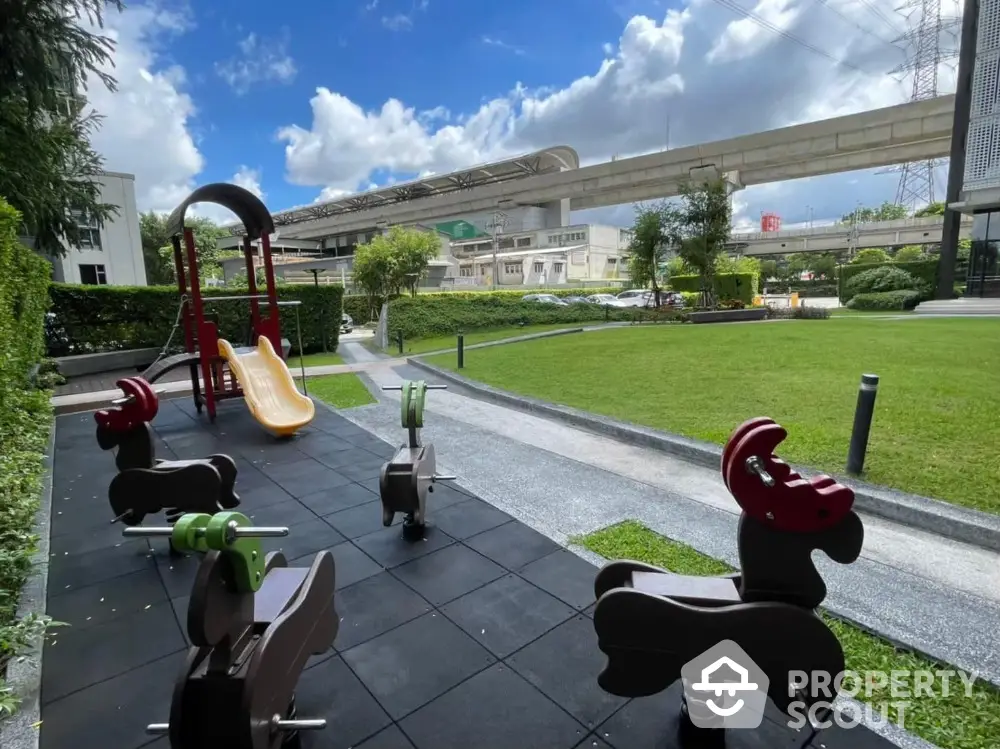 Modern residential playground with lush green lawn and nearby transit access