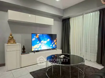 Modern living room with sleek decor and large TV, perfect for relaxation and entertainment.