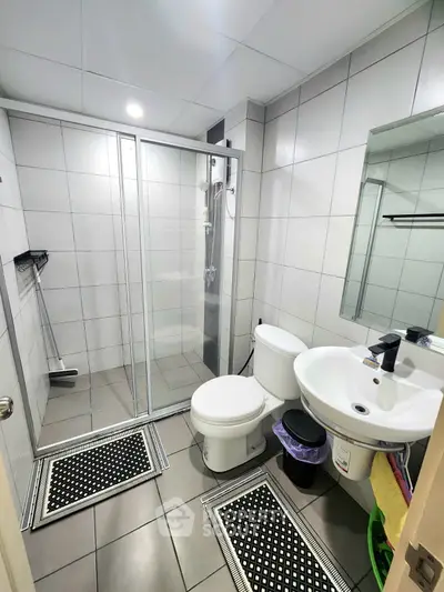 Modern bathroom with glass shower and sleek white fixtures in a contemporary home.