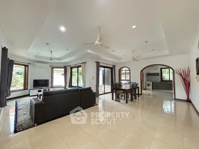 Spacious open-plan living room with modern furniture and large windows